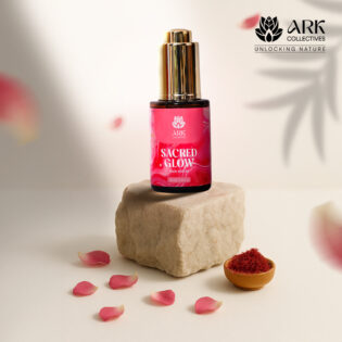 Sacred Glow face serum bottle placed on a stone with saffron